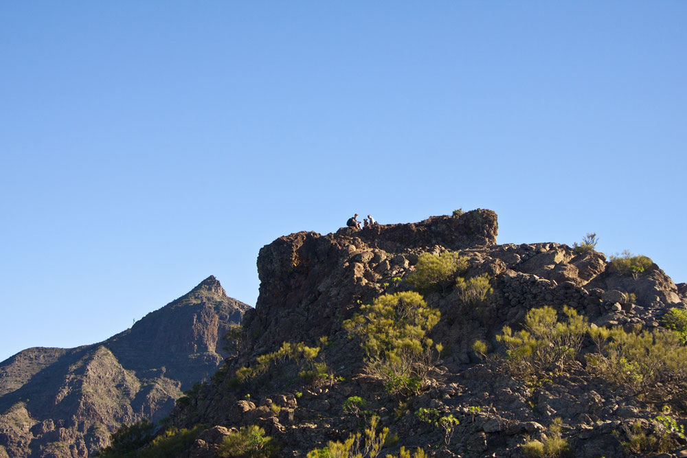 Wanderer auf Felsen am Guergues Steig