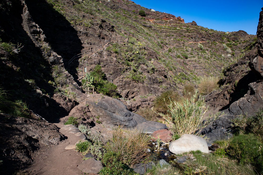Wanderweg über dem Barranco am Felsen entlang - Tamadite Schlucht