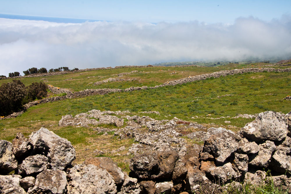 grüne Weiden, Felsen, Steine und vorbeiziehende Wolken