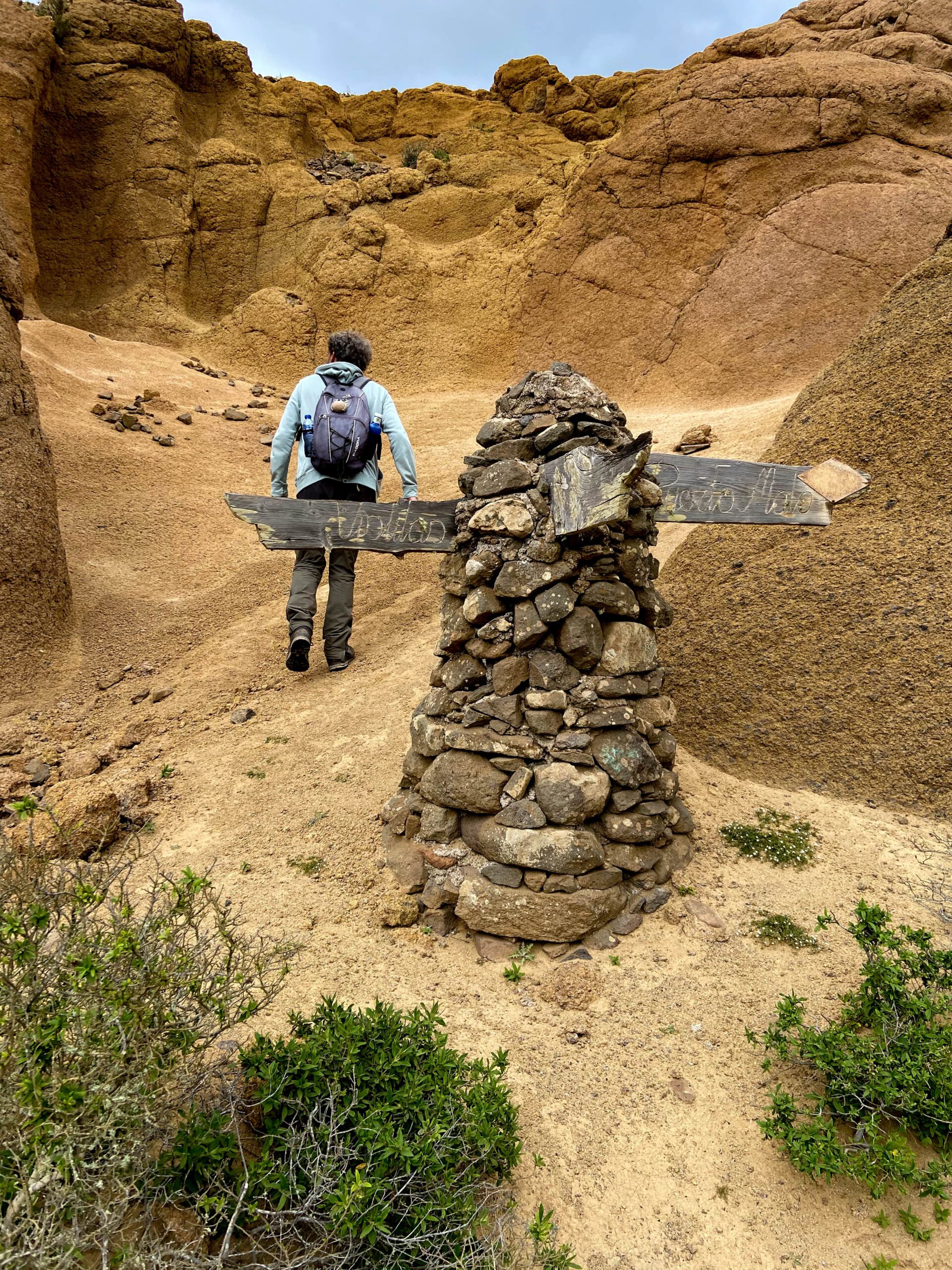 Felsformationen mit Höhlen und Figuren am Wegesrand
