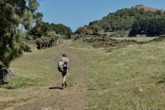 Wanderer auf grünen Wiesen - Wanderweg Richtung Meseta de Nisdafe