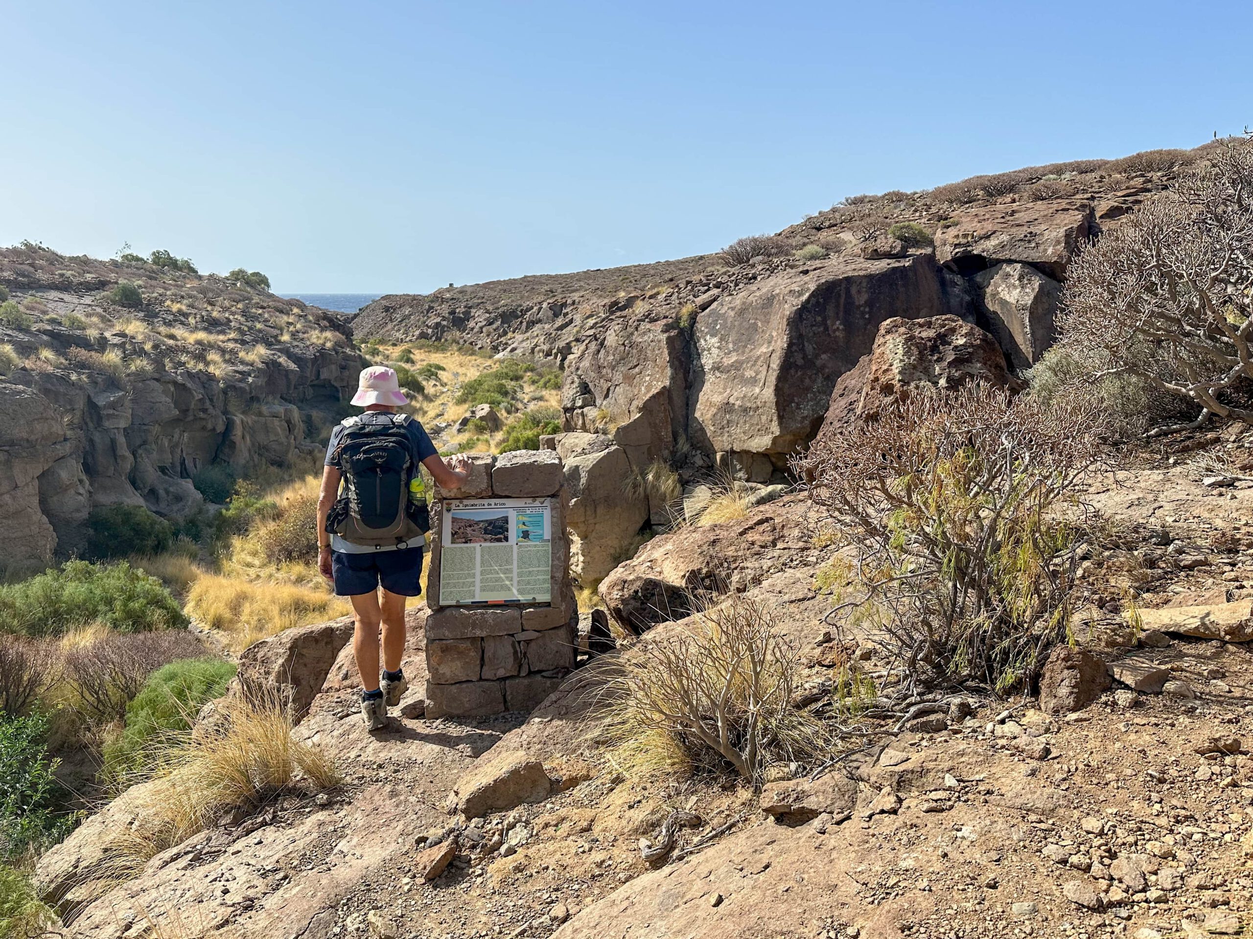 Hiker on the hiking trail from Arco de Tajao in Barranco Vijigua down to the coast